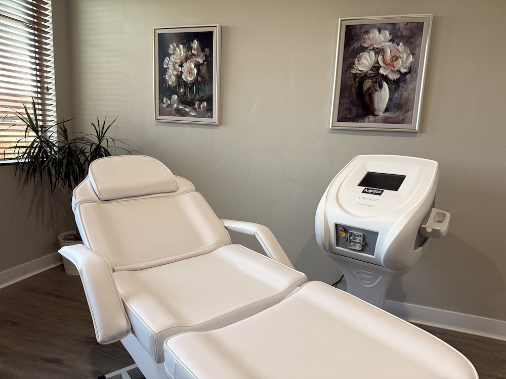 Private electrolysis treatment room with a treatment table, equipment, and natural light